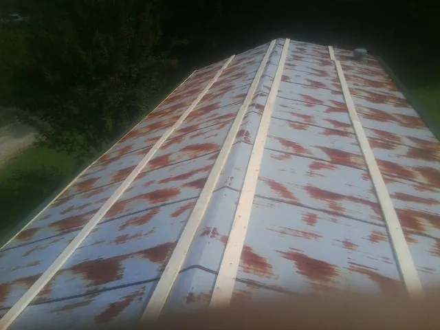 Rusted metal roof panels with new wood purlins before replacement — Storm Damage Roof Repair in Pierce by Roofing Brothers